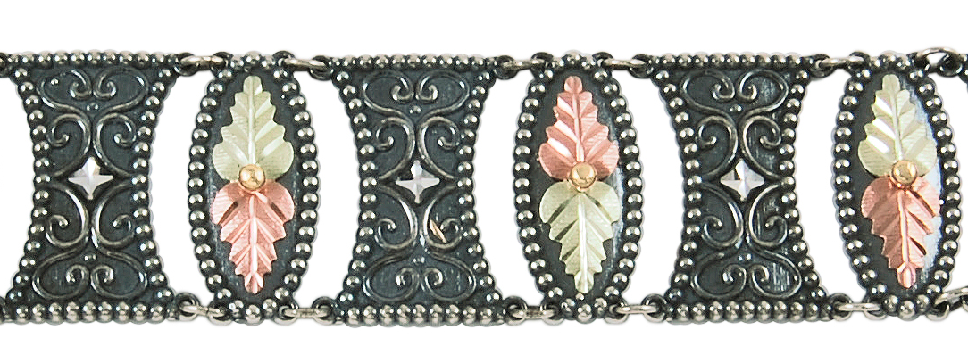 Detailed close up of womens black oxidized etruscan style bracelet in black hills gold motif.