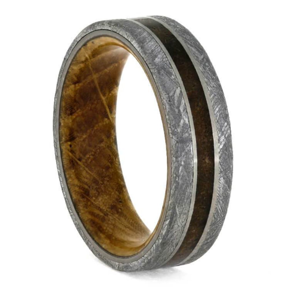 Genuine meteorite and exotic petrified wood decorate this masculine fossil wedding band. The ancient inlays on the outside of this natural ring are accented by a unique wooden sleeve. Whiskey aficionados will love the swirling wood grain with a special backstory: the sleeve is made with oak from Tennessee whiskey barrel wood. This petrified wood ring is an excellent conversation piece that is sure to stand the test of time.